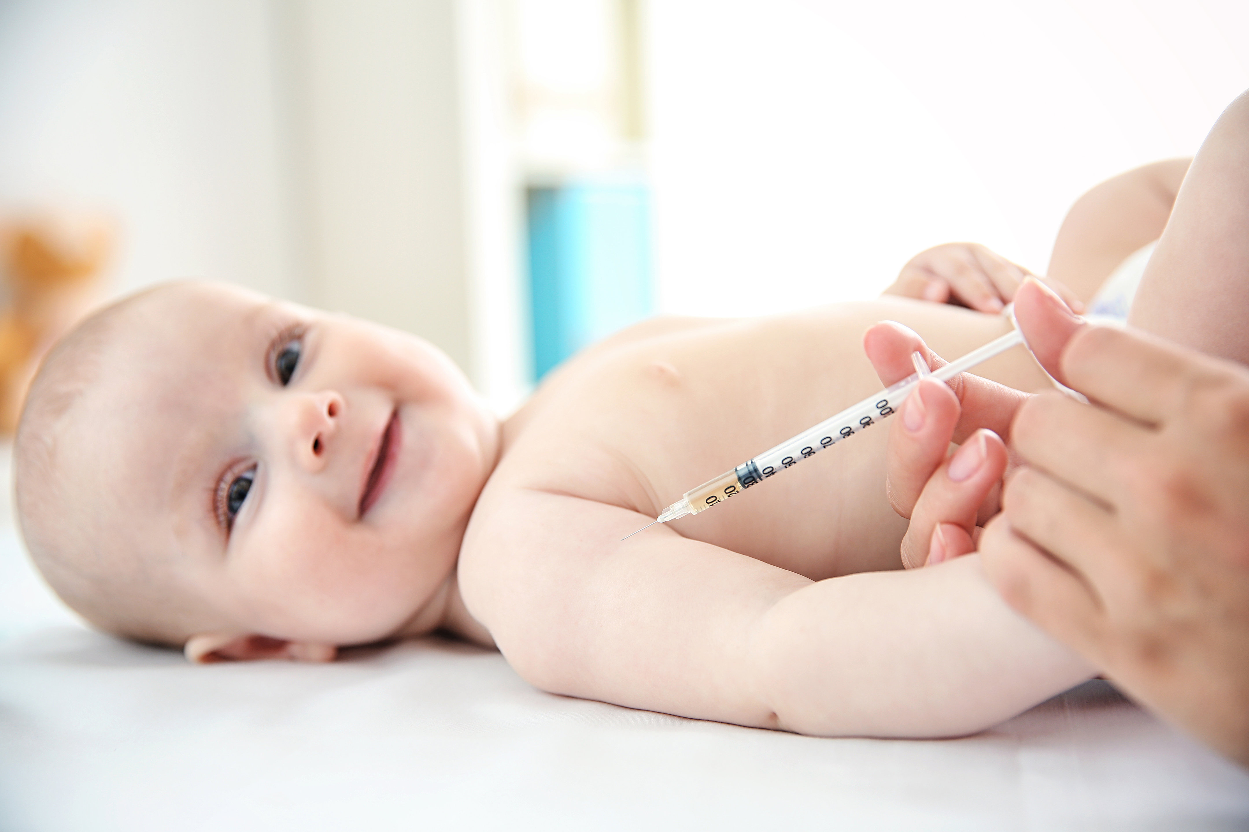 Professional pediatrician vaccinating baby, close up