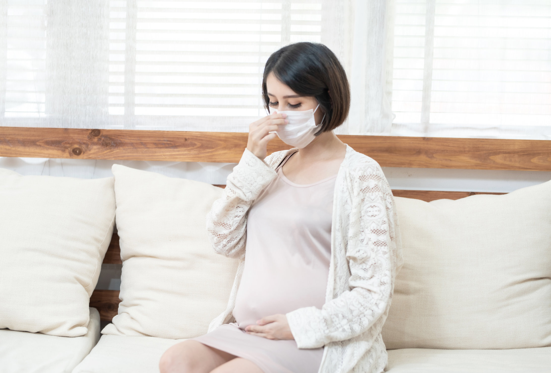 Asian pregnant women wearing surgical medical mask due to illness, dizziness ,pandemic Wuhan coronavirus (COVID-19) health care concept.